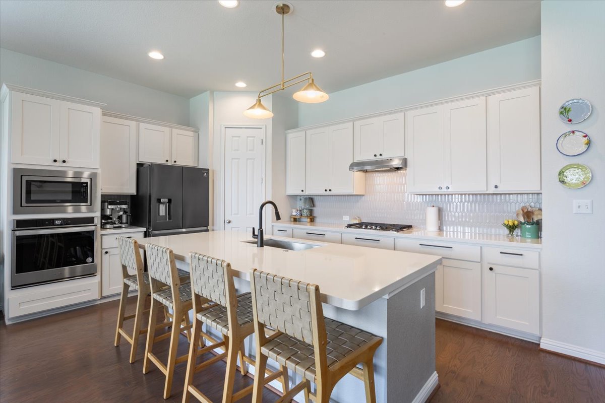424 Millard Street Georgetown, TX 78628 - Photo 13 of 37 A pristine culinary space boasts a large island, perfect for gathering, and state-of-the-art appliances.