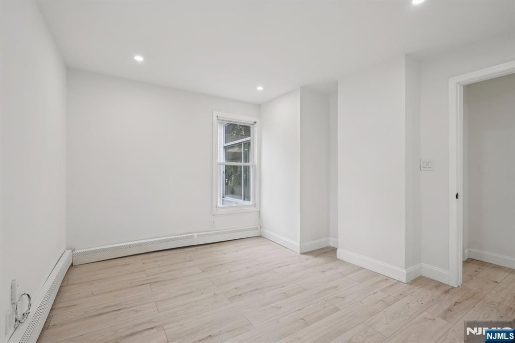 185 James Street, Unit 2 Hackensack, NJ 07601 - Photo 11 of 21 an empty room with wooden floor and windows