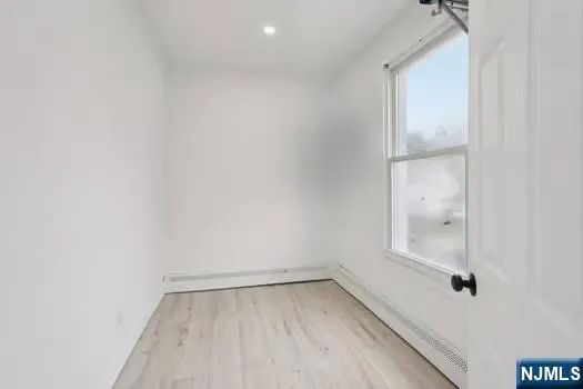 a view of a small space with wooden floor and a window