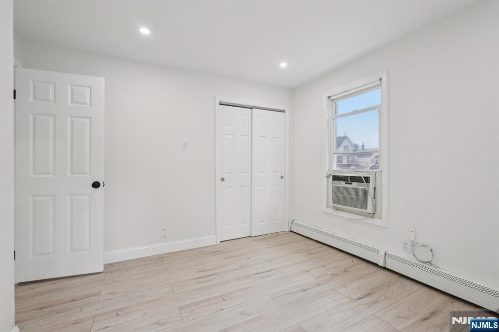 185 James Street, Unit 2 Hackensack, NJ 07601 - Photo 5 of 21 an empty room with wooden floor and windows