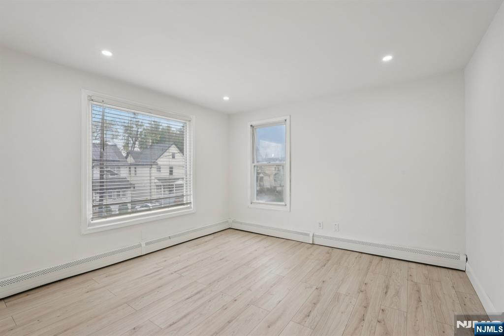 185 James Street, Unit 2 Hackensack, NJ 07601 - Photo 6 of 21 an empty room with wooden floor and windows