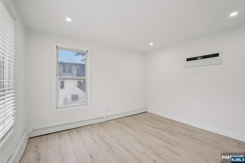 185 James Street, Unit 2 Hackensack, NJ 07601 - Photo 7 of 21 an empty room with wooden floor and windows