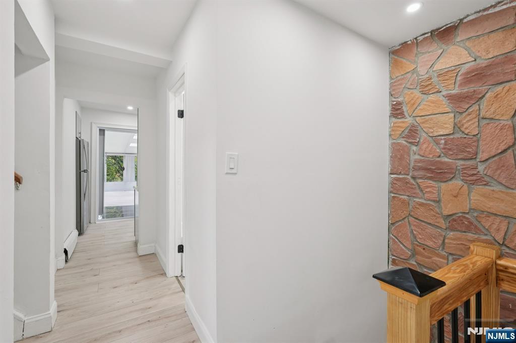 185 James Street, Unit 2 Hackensack, NJ 07601 - Photo 9 of 21 a view of a hallway with wooden floor and a bathroom