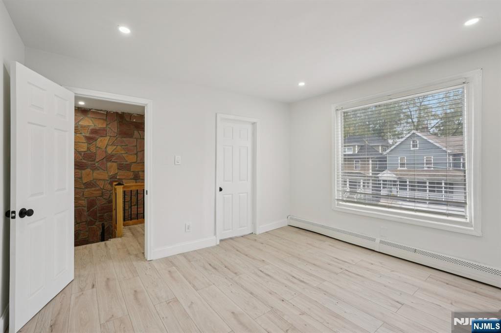 185 James Street, Unit 2 Hackensack, NJ 07601 - Photo 10 of 21 a view of an empty room with wooden floor and a window