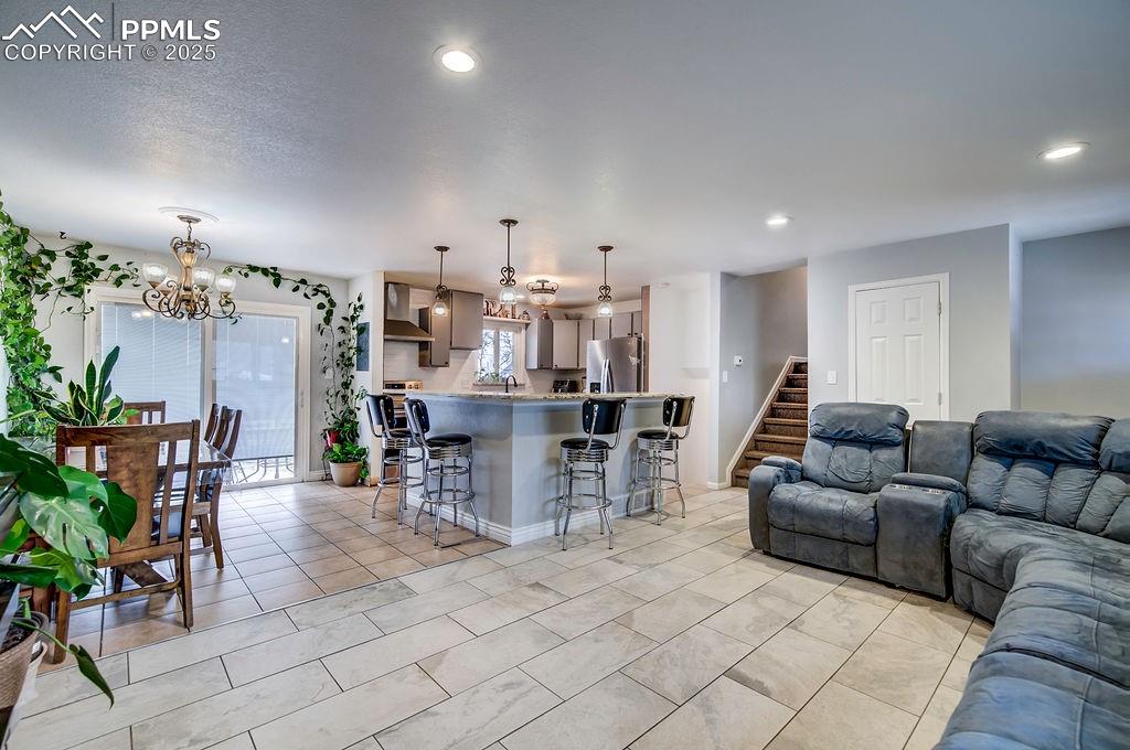 1421 Querida Drive Colorado Springs, CO 80909 - Photo 11 of 49 a living room with furniture and a dining table with potted plants