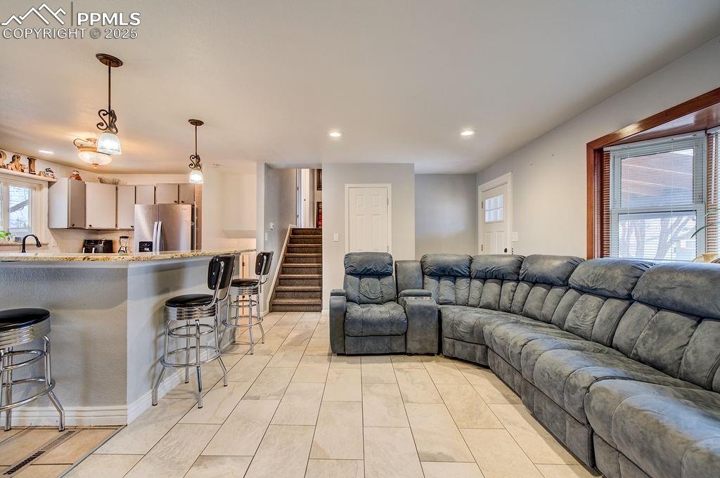 1421 Querida Drive Colorado Springs, CO 80909 - Photo 12 of 49 a living room with furniture and a dining table with kitchen view