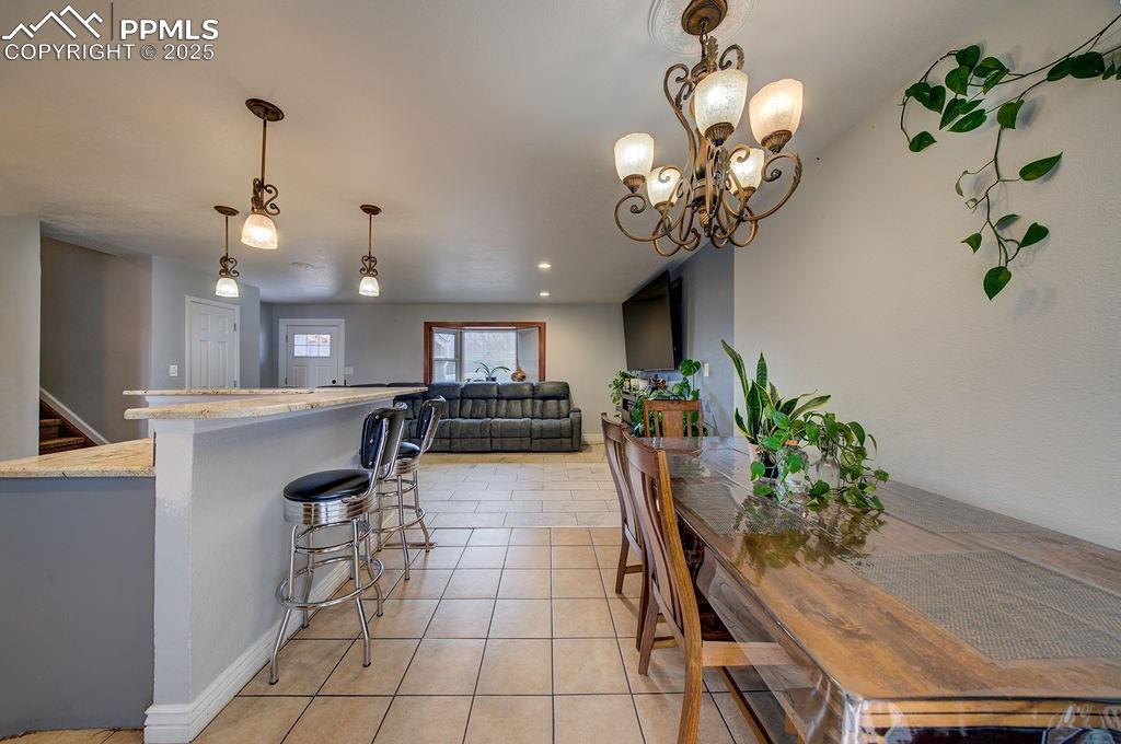 1421 Querida Drive Colorado Springs, CO 80909 - Photo 18 of 49 a dining room filled chandelier and wooden floor
