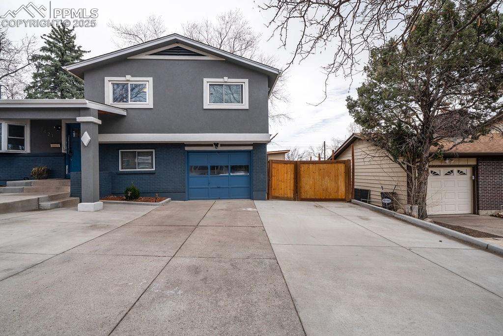 1421 Querida Drive Colorado Springs, CO 80909 - Photo 2 of 49 a front view of a house with a yard and garage