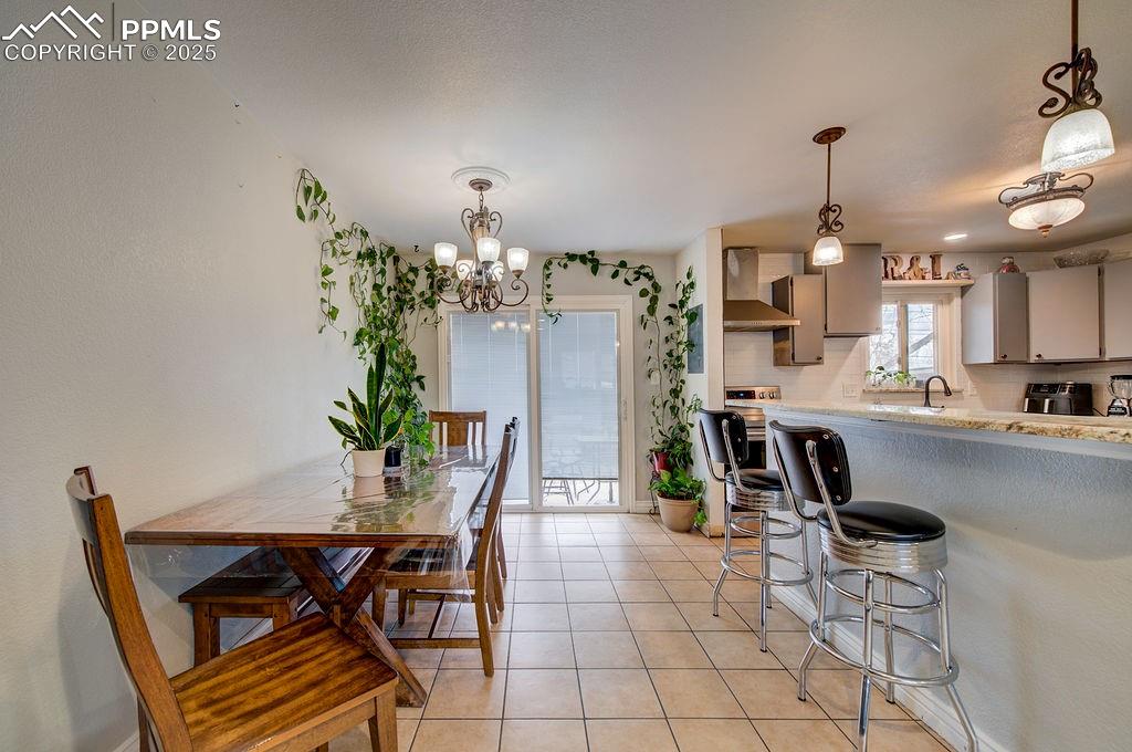 1421 Querida Drive Colorado Springs, CO 80909 - Photo 21 of 49 a view of a dining room with furniture and a chandelier