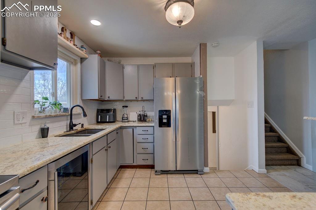 1421 Querida Drive Colorado Springs, CO 80909 - Photo 25 of 49 a kitchen with stainless steel appliances granite countertop a refrigerator sink and cabinets