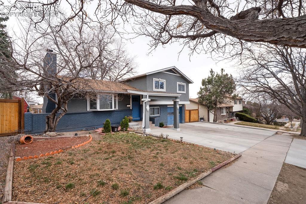 1421 Querida Drive Colorado Springs, CO 80909 - Photo 3 of 49 a front view of a house with a yard covered with snow