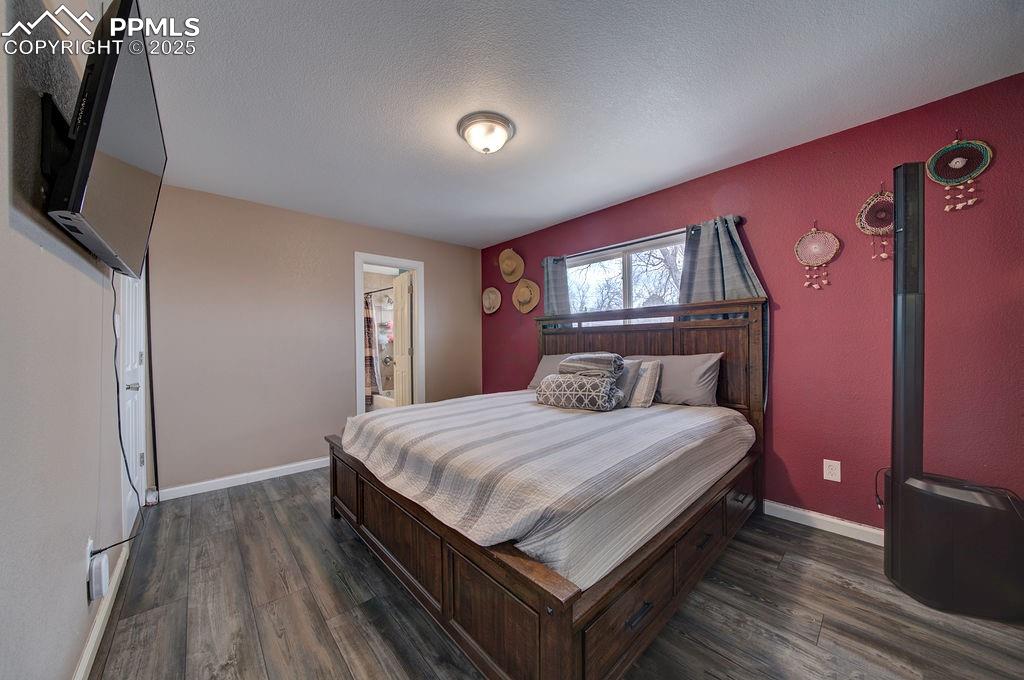 1421 Querida Drive Colorado Springs, CO 80909 - Photo 36 of 49 a bedroom with a bed a flat screen tv and dresser