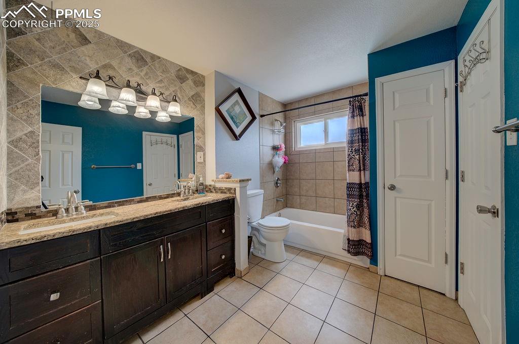 1421 Querida Drive Colorado Springs, CO 80909 - Photo 39 of 49 a bathroom with a double vanity sink a toilet and shower