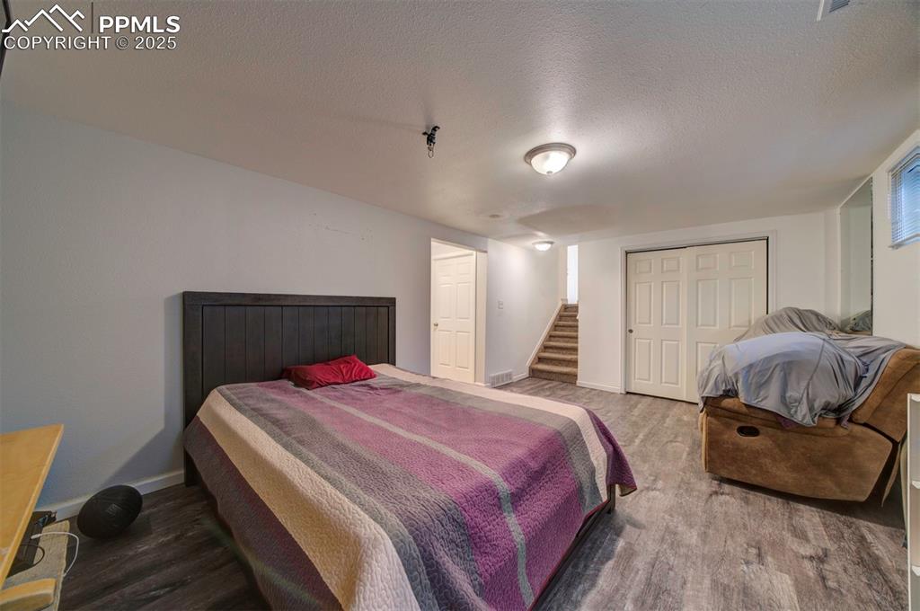 1421 Querida Drive Colorado Springs, CO 80909 - Photo 42 of 49 a bedroom with a bed and wooden floor