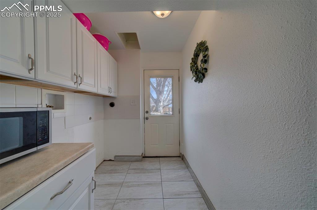 1421 Querida Drive Colorado Springs, CO 80909 - Photo 46 of 49 a room with cabinets and dust bin