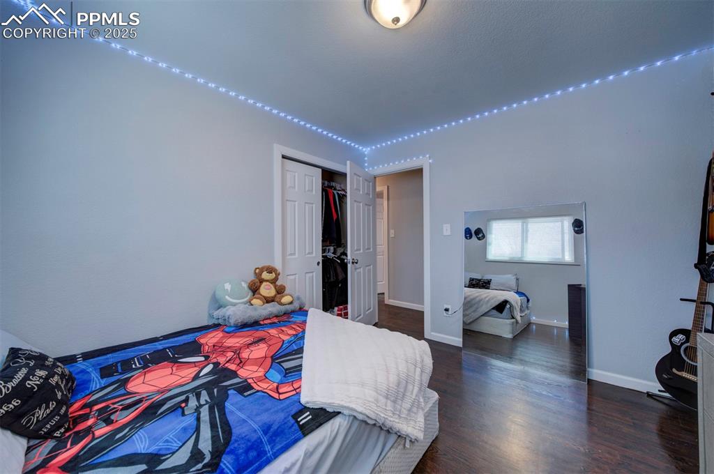 1421 Querida Drive Colorado Springs, CO 80909 - Photo 47 of 49 a bedroom with a bed and wooden floor