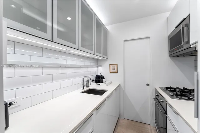 a kitchen with a sink a stove and cabinets