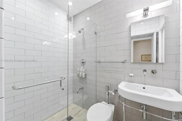 a bathroom with a sink shower and a mirror