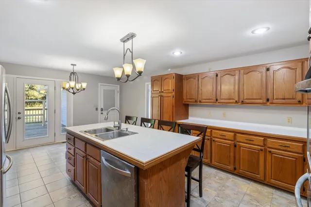 a kitchen that has a sink a stove and chairs
