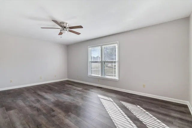 a view of a livingroom with wooden floor and a ceiling fan