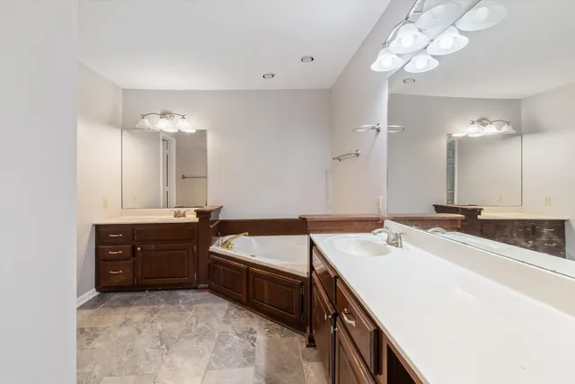 a bathroom with a bathtub and a double vanity sink