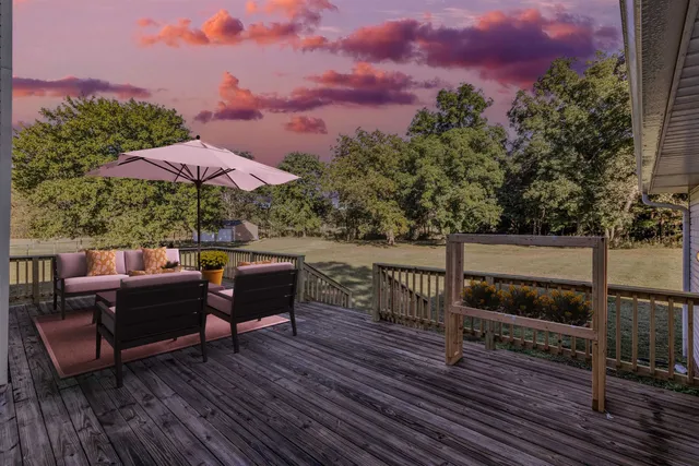 an outdoor sitting area with furniture and wooden floor