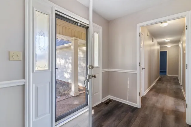 a view of a hallway with wooden floor and glass door