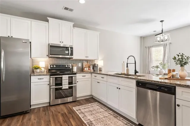 a kitchen with granite countertop a refrigerator and a sink