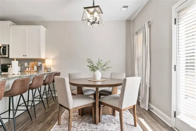 a dining room with furniture a chandelier and wooden floor