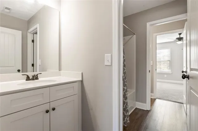 an empty room with windows and ceiling fan