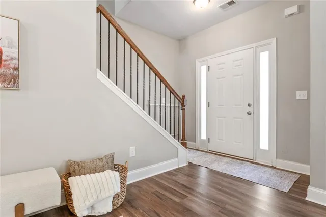 a view of a hallway with wooden floor and stairs