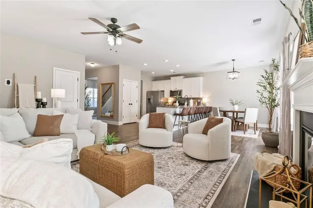 a living room with furniture kitchen view and a chandelier