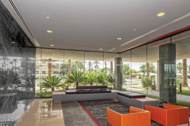 a front view of a building with a garden and plants