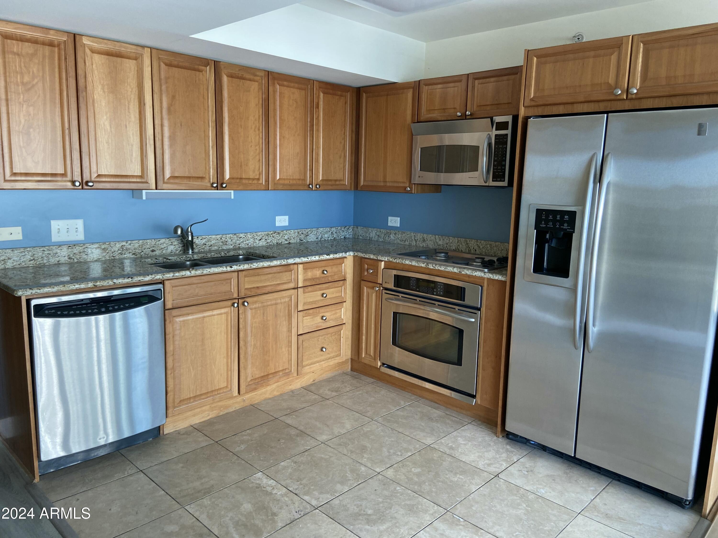 4808 North 24th Street, Unit 902 Phoenix, AZ 85016 - Photo 5 of 17 a kitchen with granite countertop cabinets stainless steel appliances and a counter space