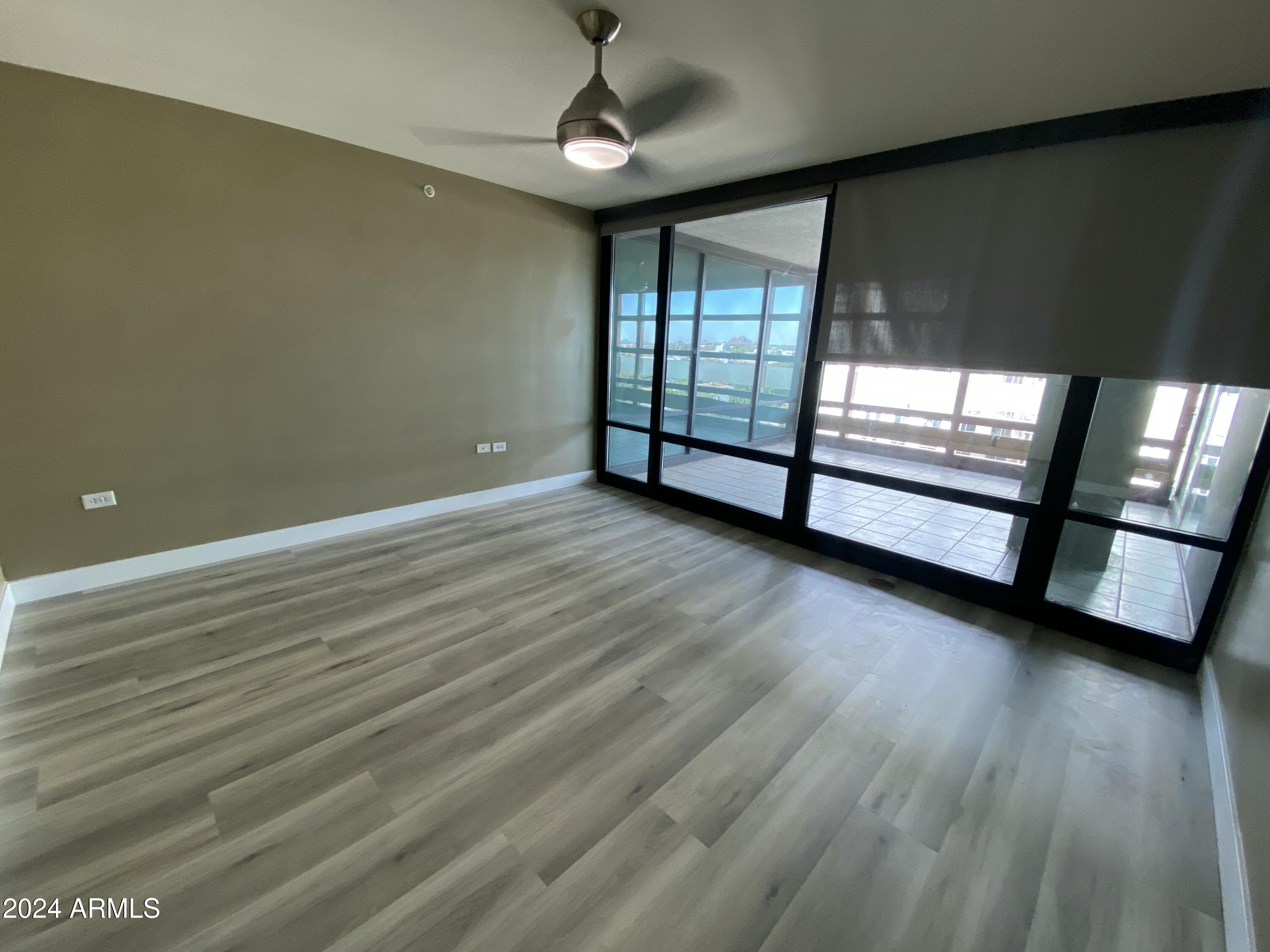 4808 North 24th Street, Unit 902 Phoenix, AZ 85016 - Photo 7 of 17 an empty room with wooden floor and windows