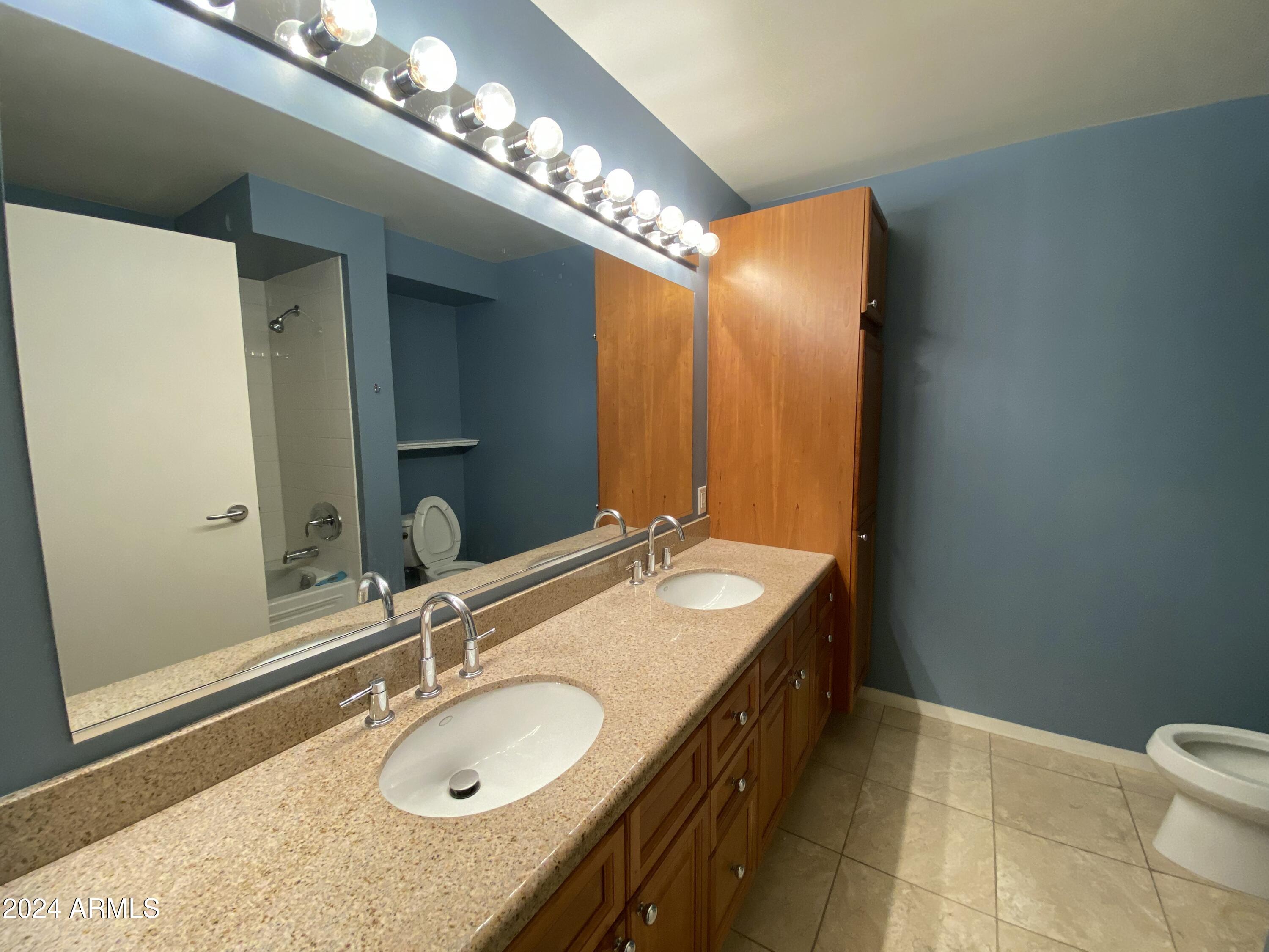 4808 North 24th Street, Unit 902 Phoenix, AZ 85016 - Photo 9 of 17 a bathroom with a granite countertop double vanity sink and a mirror