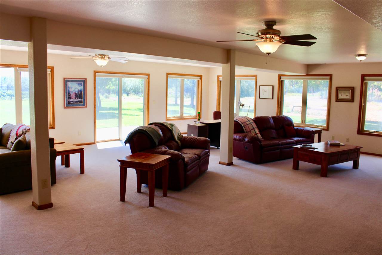 53716 Falcon Road Olathe, CO 81425 - Photo 11 of 39 a living room with furniture a ceiling fan and a large window