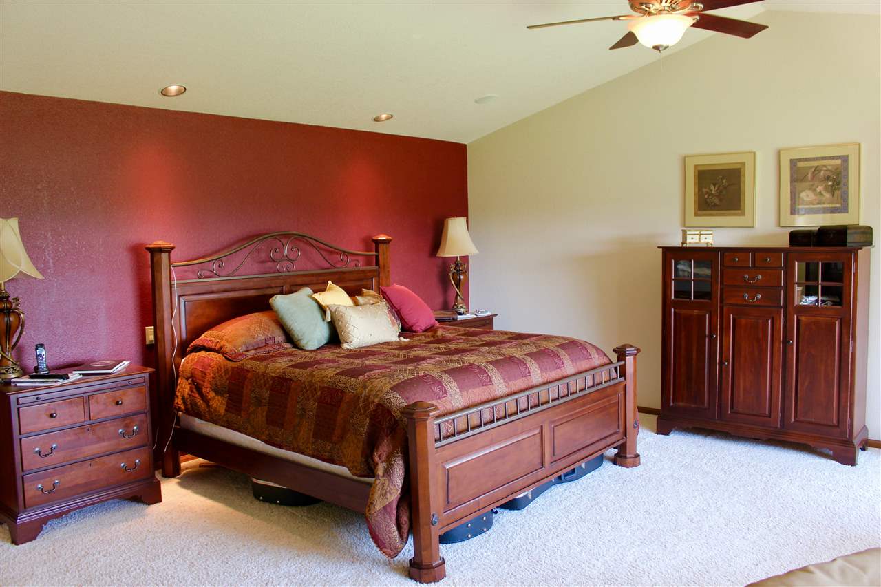 53716 Falcon Road Olathe, CO 81425 - Photo 36 of 39 a bed sitting in a bedroom next to a cabinet and a chandelier