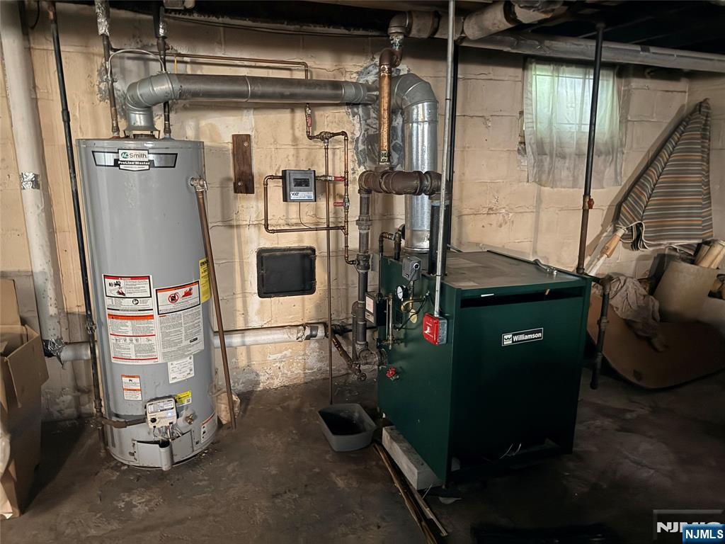 599 South Center Street Orange, NJ 07050 - Photo 18 of 19 a room with water heater and wooden cabinets