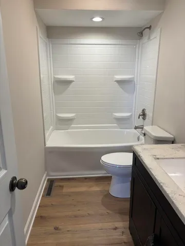 a bathroom with a granite countertop sink toilet a mirror and shower
