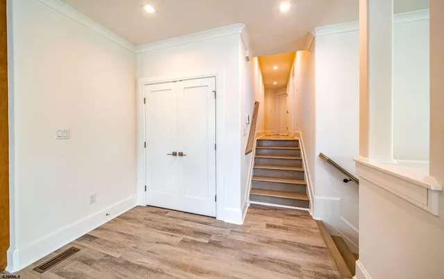 a view of a hallway with wooden floor and entryway