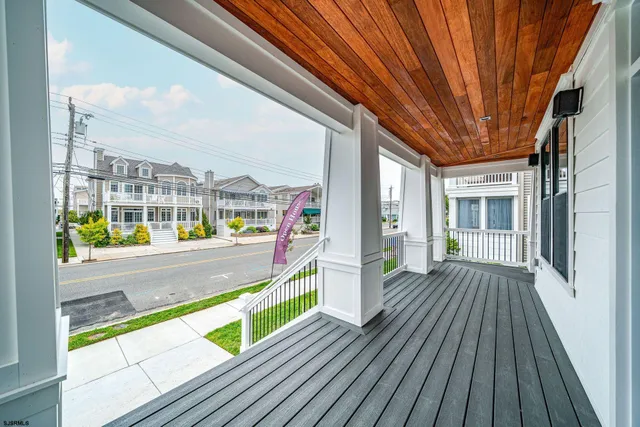 a view of an empty room with wooden floor and windows