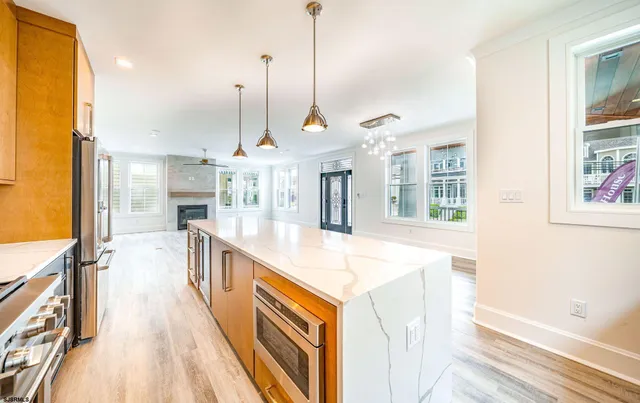 a kitchen with kitchen island a stove a sink a refrigerator and windows