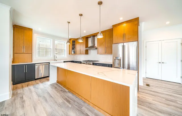 a large kitchen with stainless steel appliances granite countertop a granite counter tops and a wooden floor