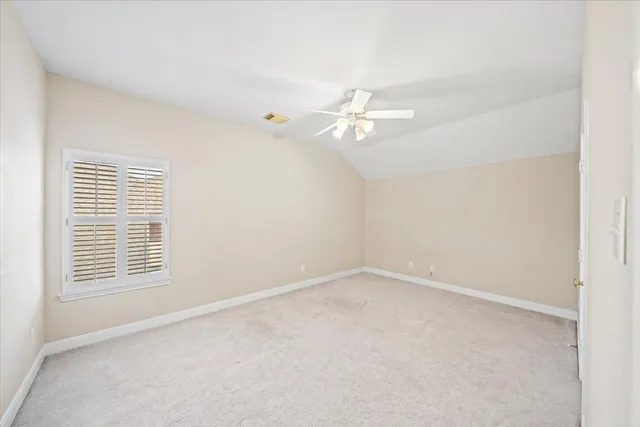 an empty room with windows and ceiling fan