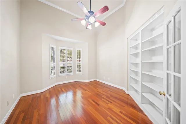 a view of an empty room with a window and wooden floor