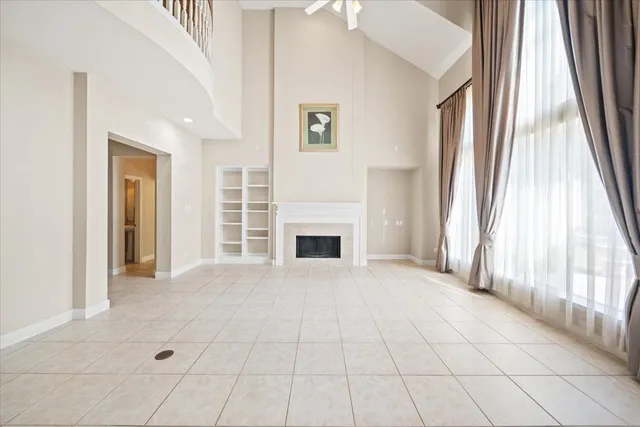 a view of an empty room with a fireplace and a window