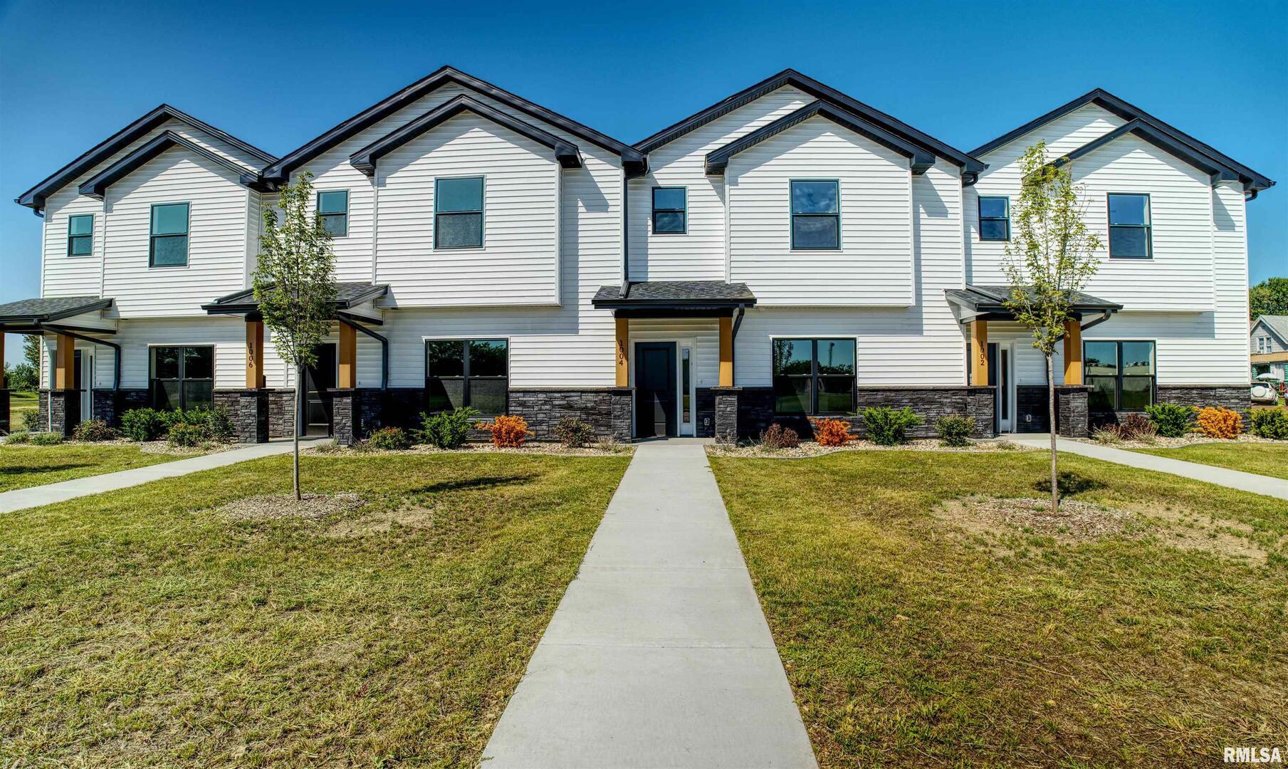 a front view of a house with a yard and dinning table