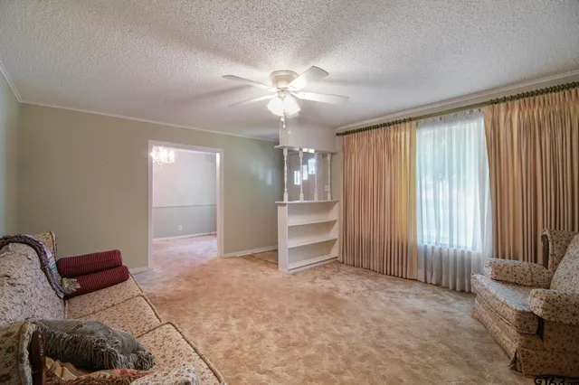 an empty room with windows and ceiling fan