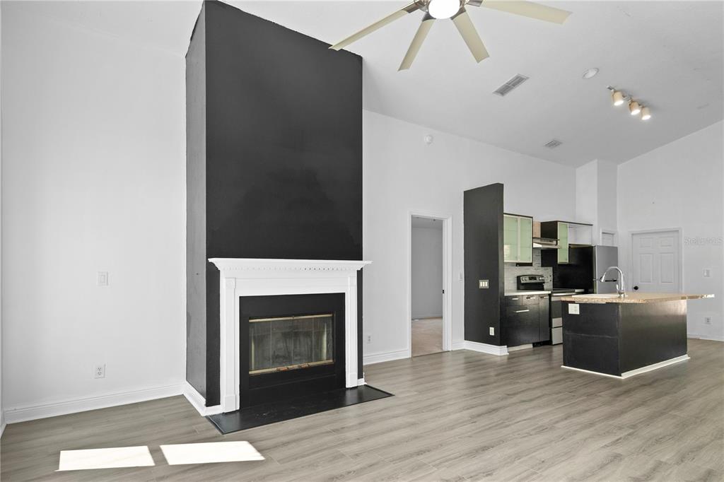 11748 Constance Way Clermont, FL 34711 - Photo 14 of 45 a living room with stainless steel appliances furniture a fireplace and wooden floor